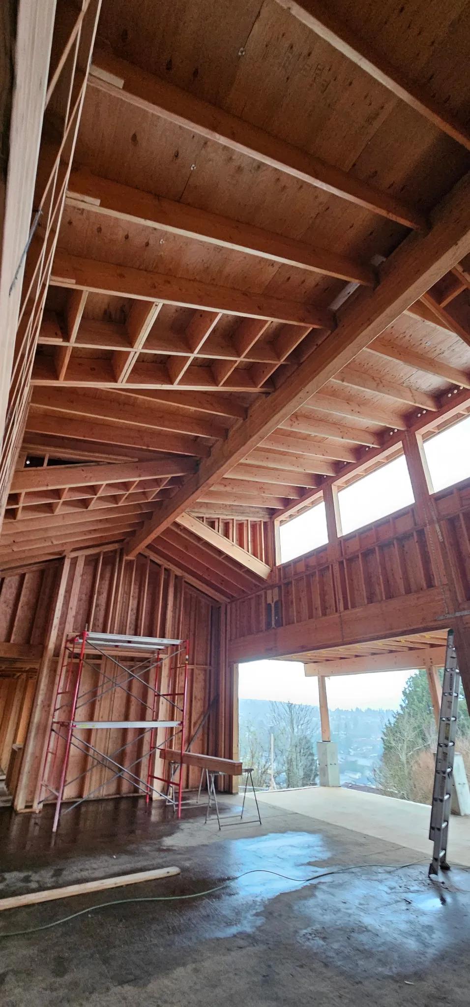 Vaulted interior framing with exposed timber beams, high clerestory windows, and scaffolding
