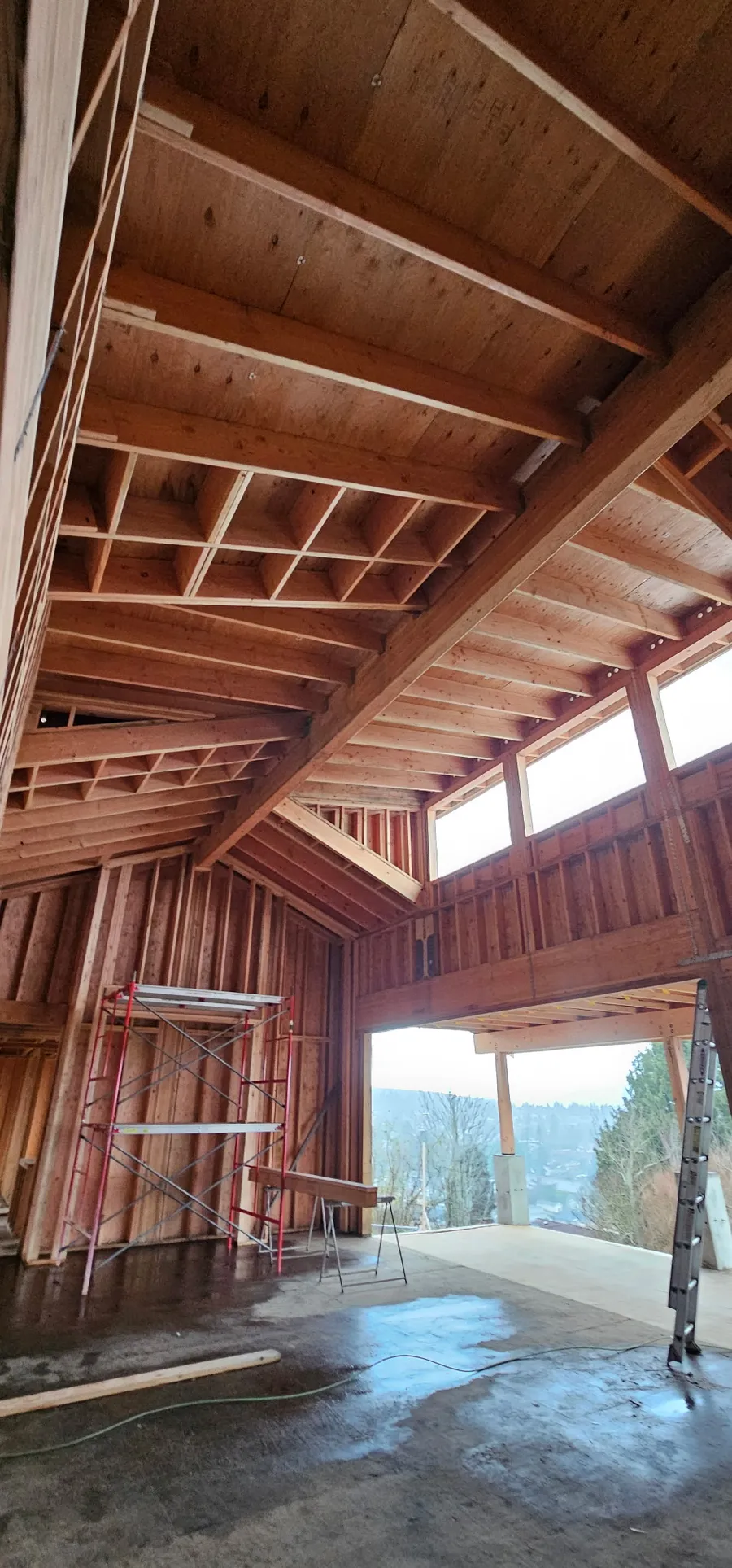 Vaulted interior framing with exposed timber beams, high clerestory windows, and scaffolding